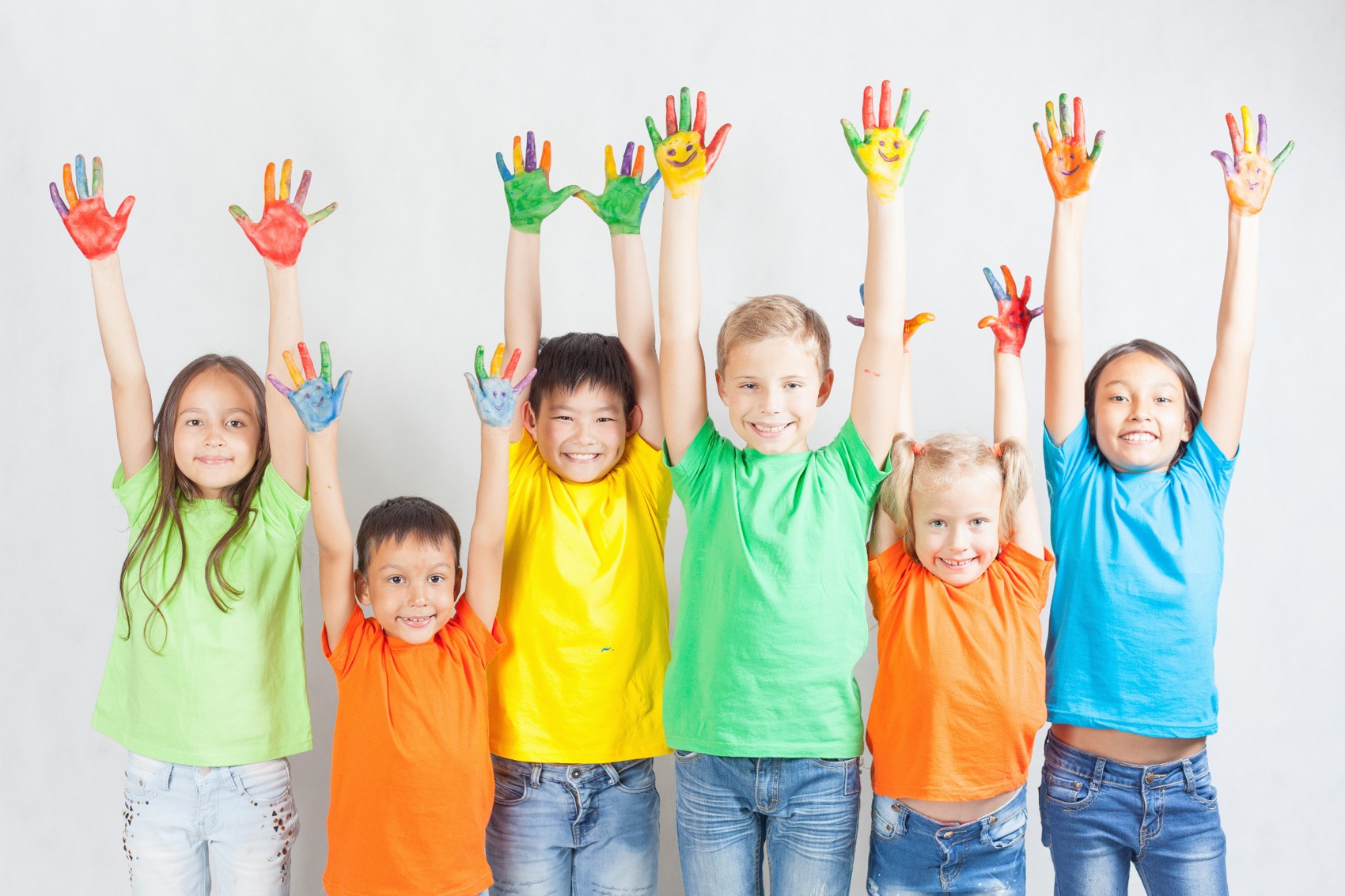 Children raising hands covered in colourful paint